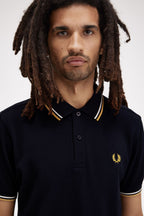 Polo de algodón doble banda negro dorado Fred Perry