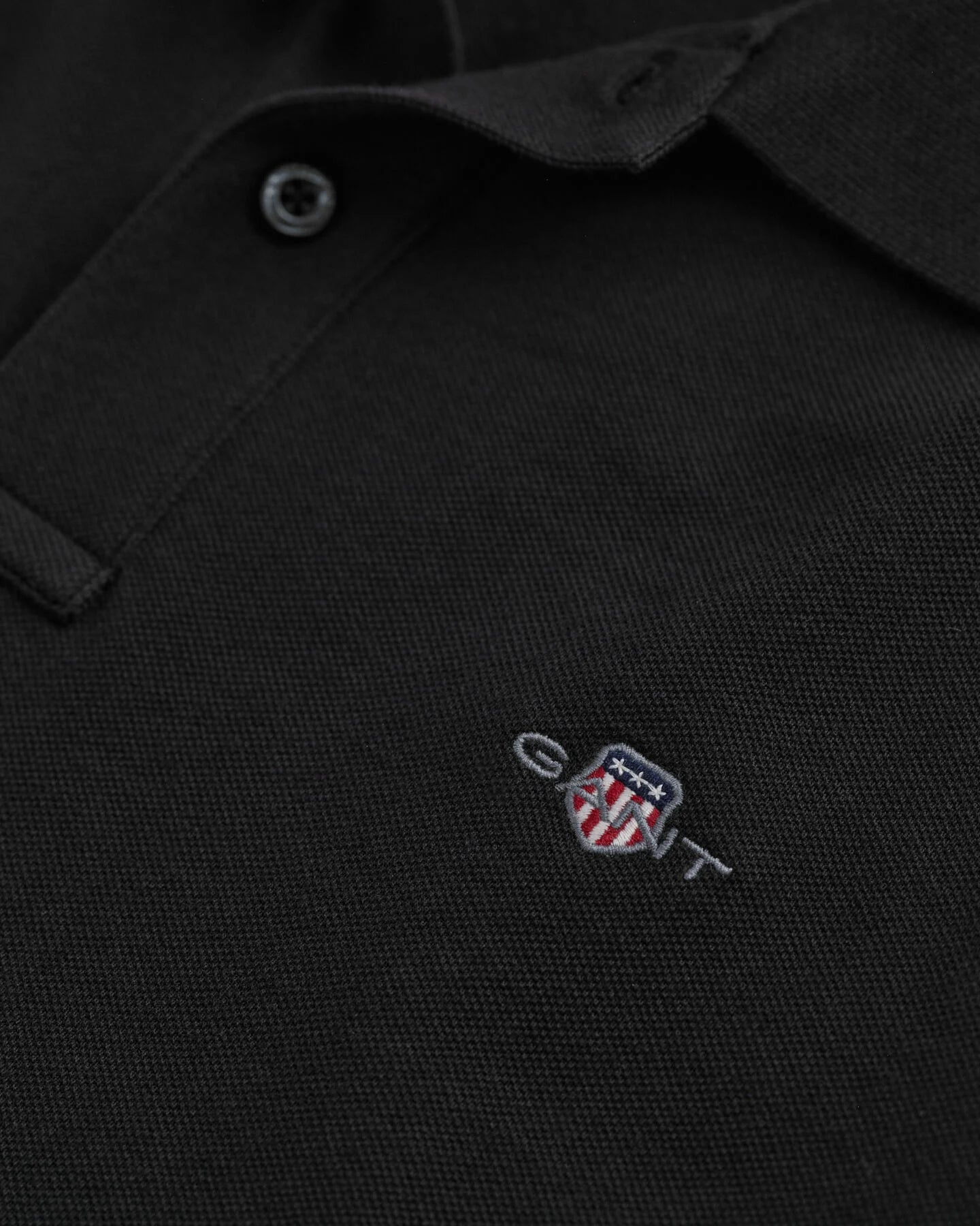 detalle logo gant bordado en polo negro algodón